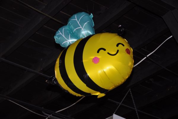 Bee-shaped balloon decoration hangs from the ceiling as part of the JeopardBee event decorations.