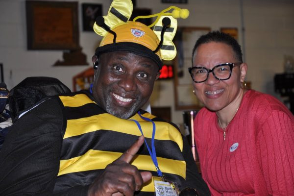 Attendee dressed in a bee costume smiles with another guest during Danville Project Literacy’s JeopardBee event.