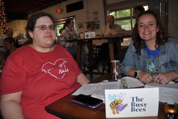 The Busy Bees team sits at a table with JeopardBee materials during Danville Project Literacy’s event.