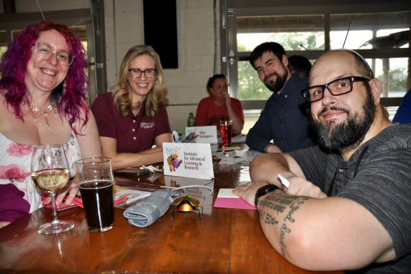 Institute for Advanced Learning and Research team members smile at their table during the JeopardBee competition.