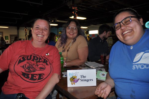 The Stingers team members smile together at their table during Danville Project Literacy’s JeopardBee competition.